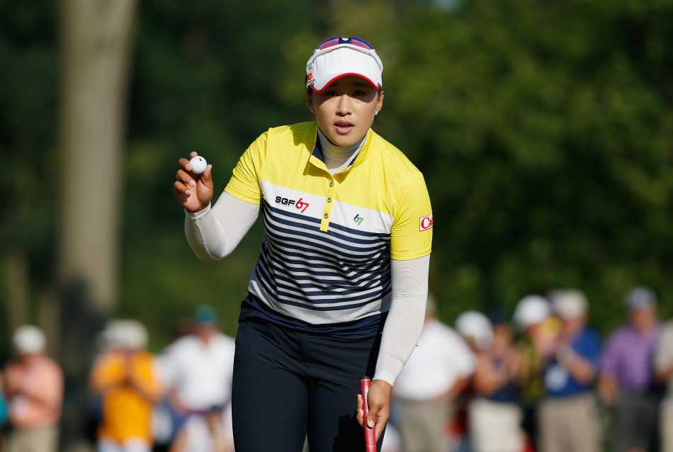 梁熙英完成一次精准推击后，小球正滚向球洞，她的目光紧紧跟随，表情专注而坚定