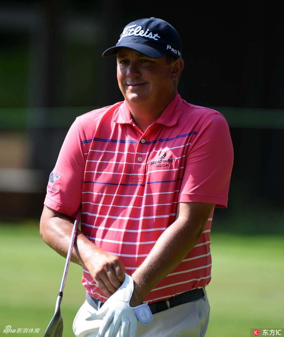 球员在发球台完成大幅度的全力挥杆，身体扭转充满力量，球杆划破空气。