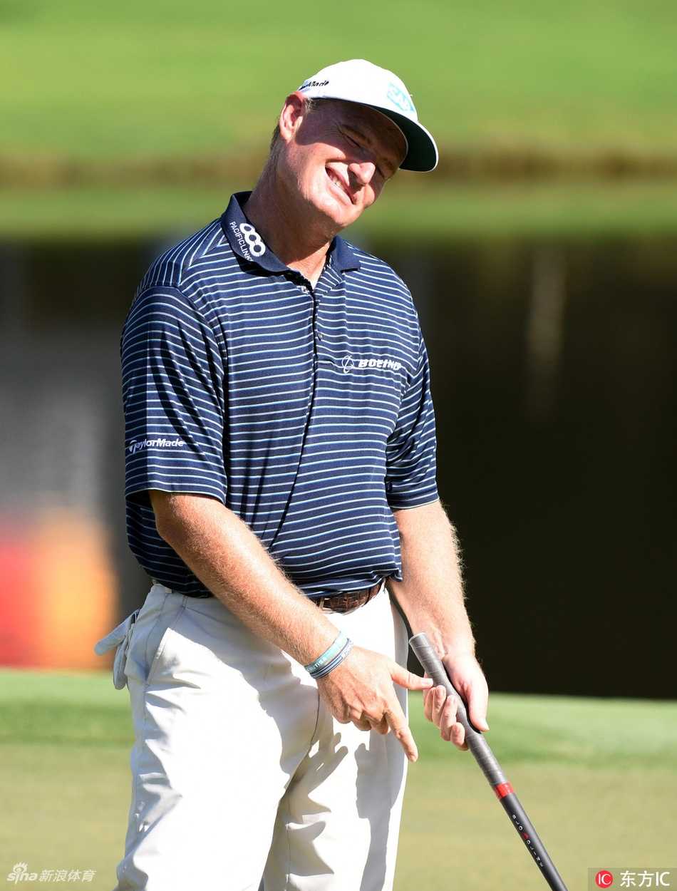 赛事工作人员在果岭旁整理旗杆与球洞，他们是赛事顺利运行的幕后功臣。