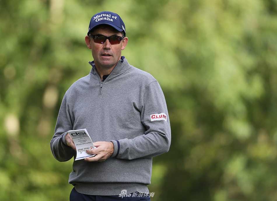 观众聚集在沙坑环绕的果岭旁，屏息观看关键推杆