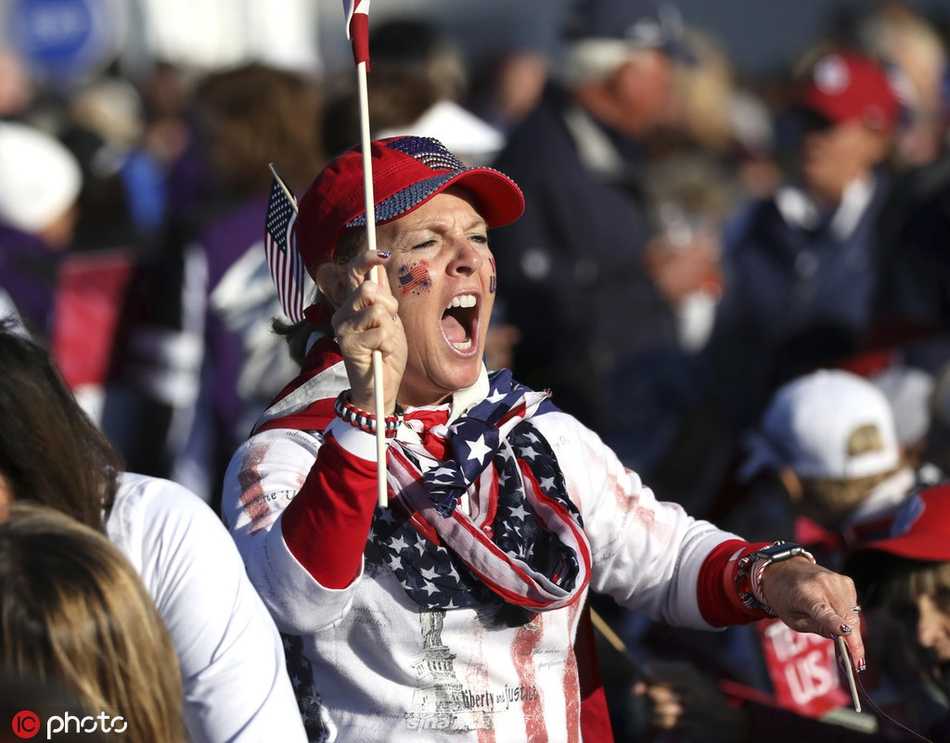 莎琳·斯皮特里身着一袭优雅长裙，立于舞台中央的聚光灯下，手握麦克风，眼眸中闪烁着对家乡与音乐的热爱，身后是深邃的夜空与隐约可见的索尔海姆杯标志。