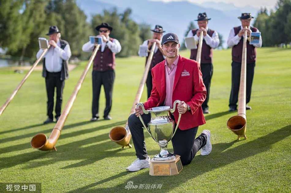 冠军阿伯格高举银光闪闪的奖杯，身旁的亚季军得主一同喷洒香槟庆祝