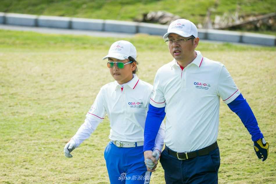 中国高尔夫名将梁文冲与爱女温馨同框，父女二人身着亲子运动装，在果岭上相视而笑，画面充满爱与传承的意味。