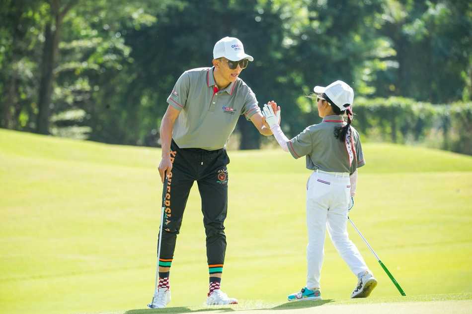 颁奖时刻，小冠军高举奖杯绽放灿烂笑容，身后是鼓掌祝贺的同伴与家长，荣誉与喜悦在赛场弥漫。