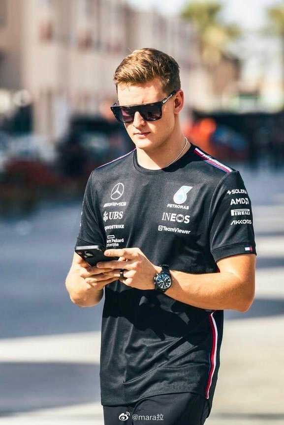 阿尔法·罗密欧车队技师在车库内为赛车前翼安装精密传感器，专注的神情与精准的动作，是科技竞赛背后无声而严谨的基石。