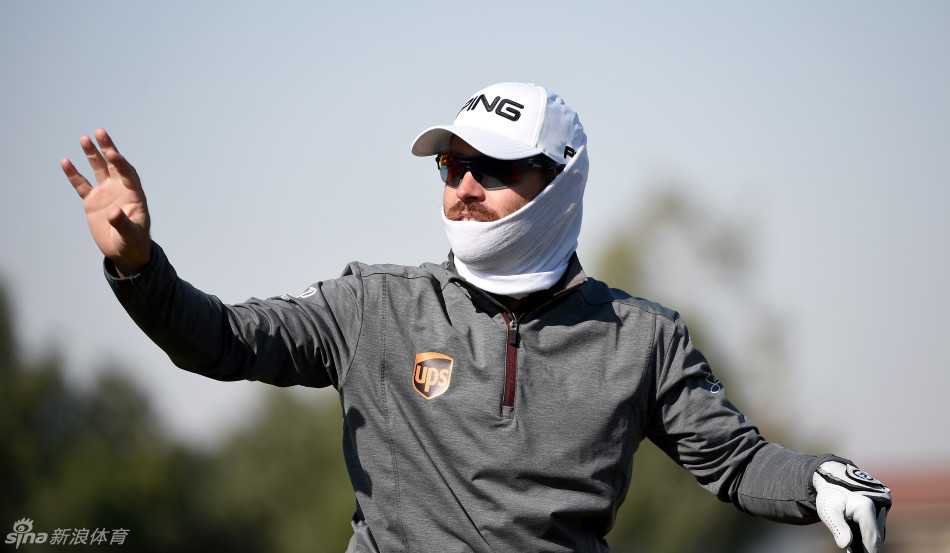 路易斯-乌休仁在果岭边进行精妙的切杆，小白球划出优雅弧线，即将层层滚向球洞。