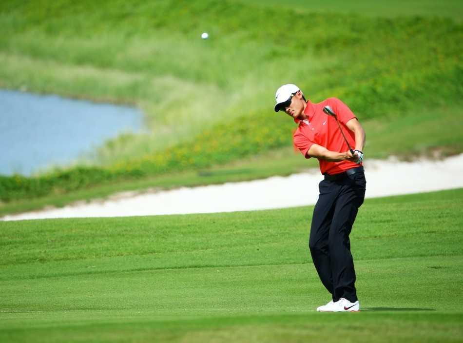 球员布莱特与他的球童并肩站在果岭上，手指远方共同商讨策略，默契的合作是赛场上的无形力量。