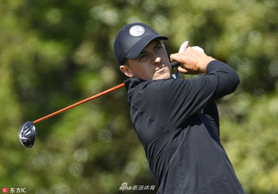 罗里·麦克罗伊在沙坑中救球，他身体绷紧，沙砾飞扬，展现了顶级球星处理困难球位的技巧与专注。