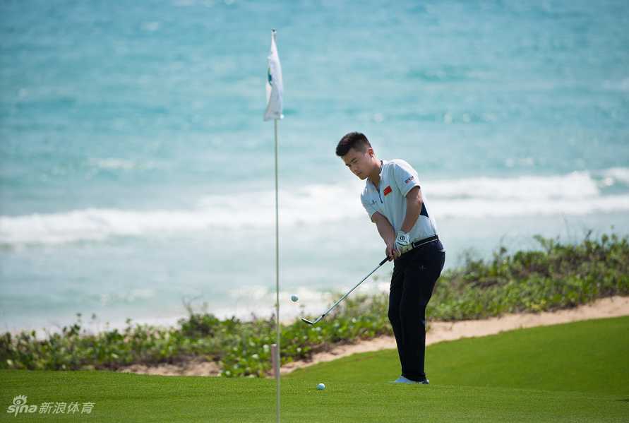 肖博文在练习果岭边专注地进行切杆练习，神情认真一丝不苟