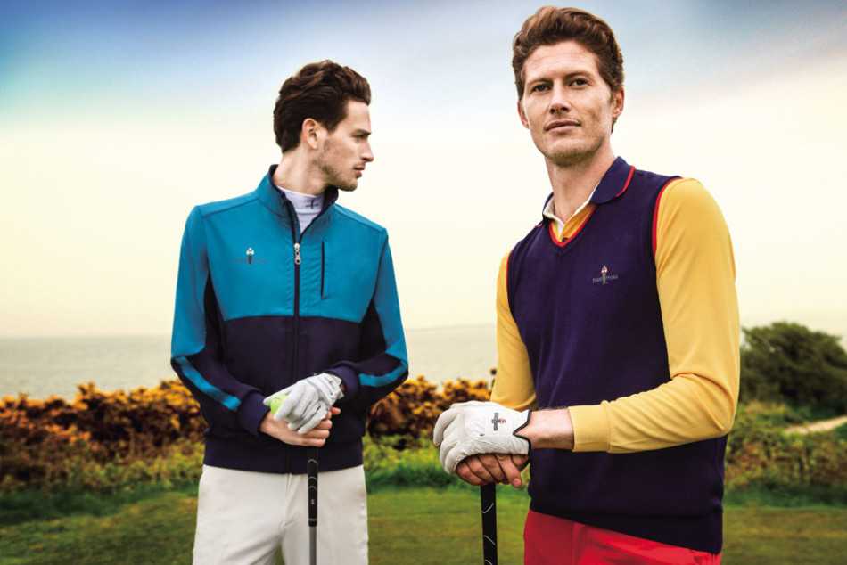 两位时尚女性在球道上相视而笑，一人身着宝蓝色修身polo裙，另一人穿着条纹拼接上衣，手中球具与着装色彩巧妙呼应，尽显运动女性的自信风采