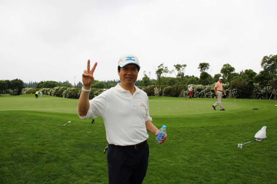 一位球手侧身专注于果岭推杆，动作稳定而优雅