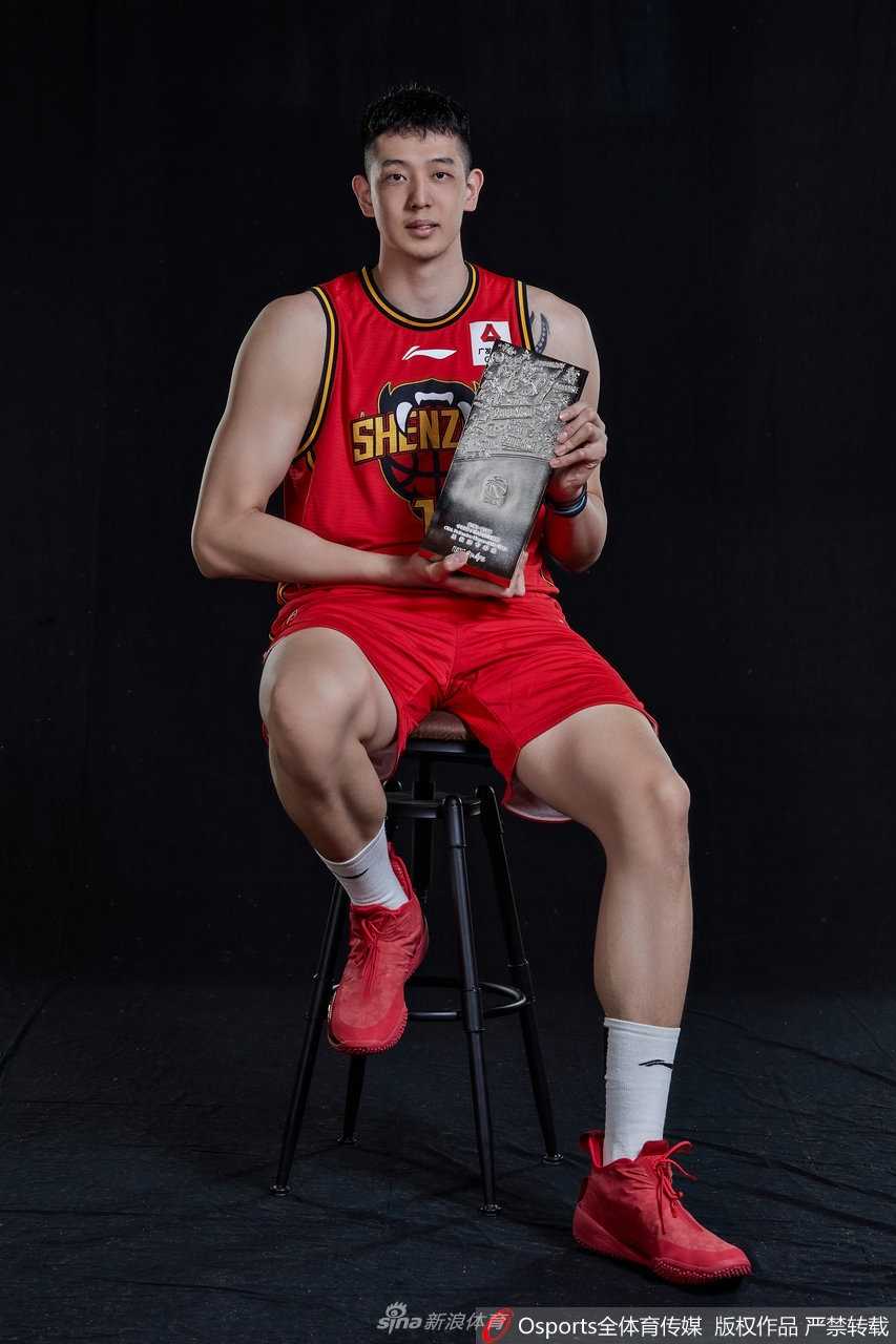 镜头聚焦于沈梓捷坚毅的面庞，他双手紧握最佳防守球员奖杯，眼神中透露出捍卫禁区的决绝与霸气。