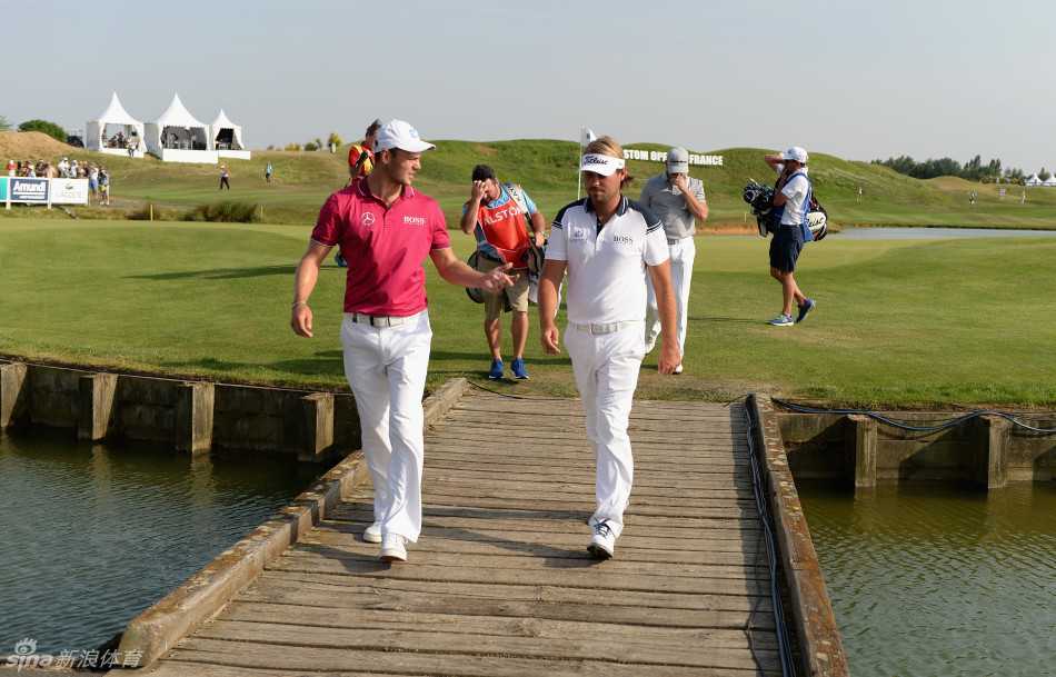 马丁·凯梅尔与维克多·杜比松在球道上谈笑风生，阳光将他们的身影拉长，气氛融洽如老友