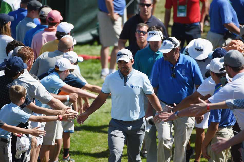 里奇福勒以其标志性的鲜艳着装和冷静神情站立在果岭边，正在观察推击线路。