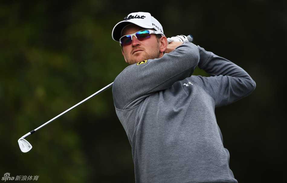 奥地利名将本德-维斯伯格在比赛中聚精会神地观察果岭推杆线路，阳光洒在绿茵上，映照着他专注的脸庞。