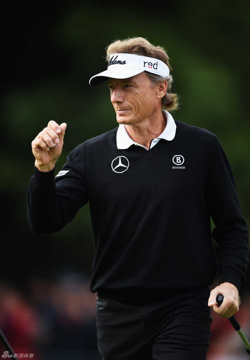 一位高尔夫球手成功从沙坑中将球击出，沙粒飞扬瞬间，小球朝着果岭旗杆方向精准飞去。